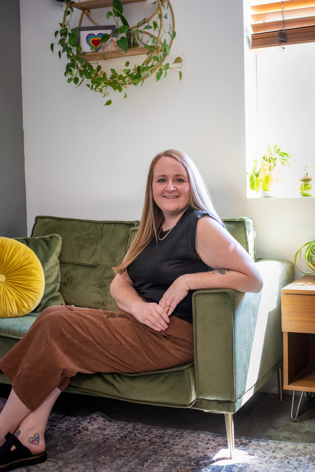 Smiling person sitting in a green chair.