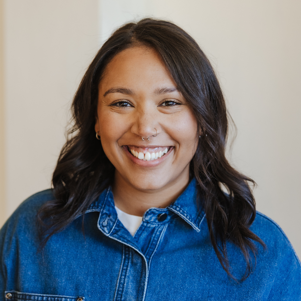 Person in a denim top, smiling.