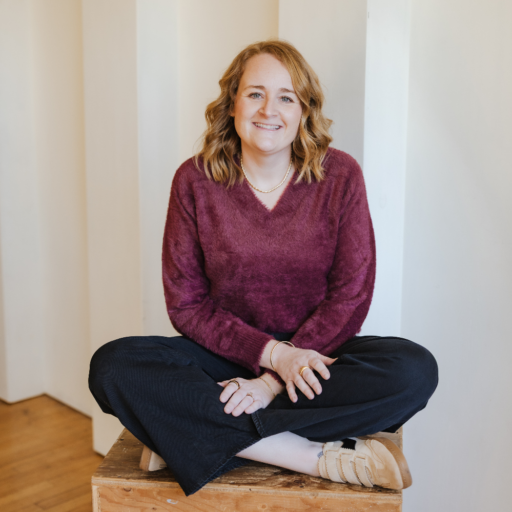 Smiling person sitting in a green chair.