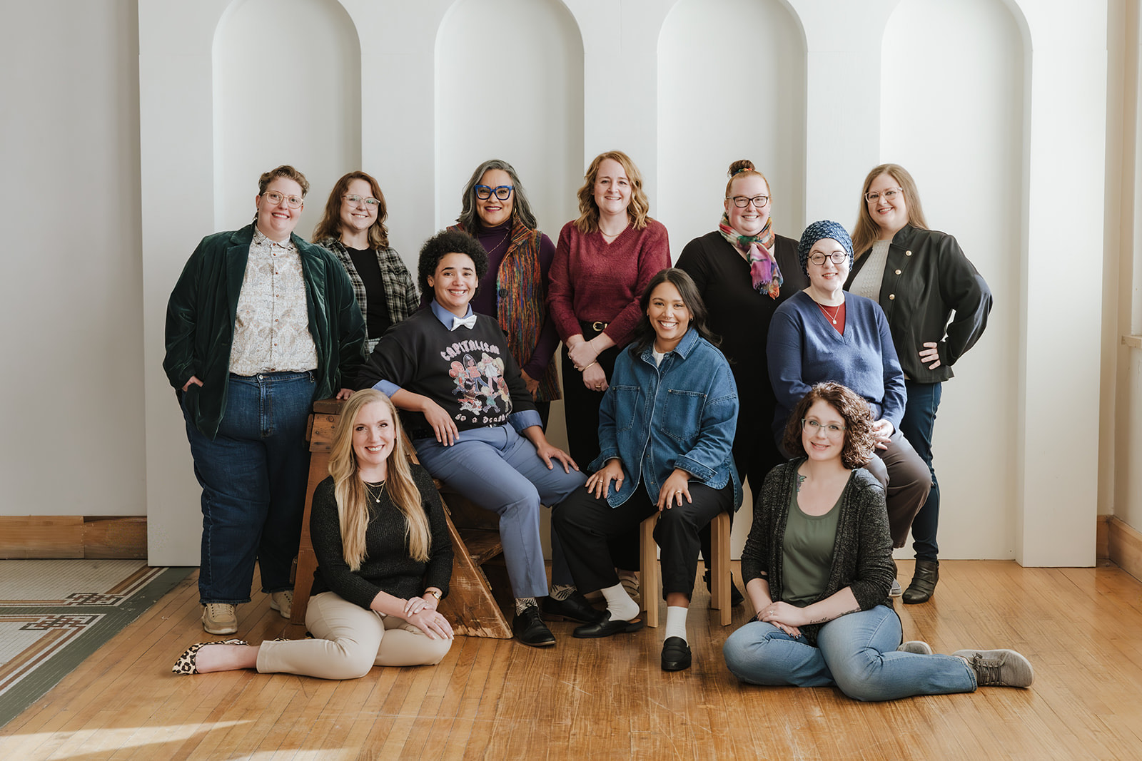 A group of people standing and sitting, smiling at the camera.