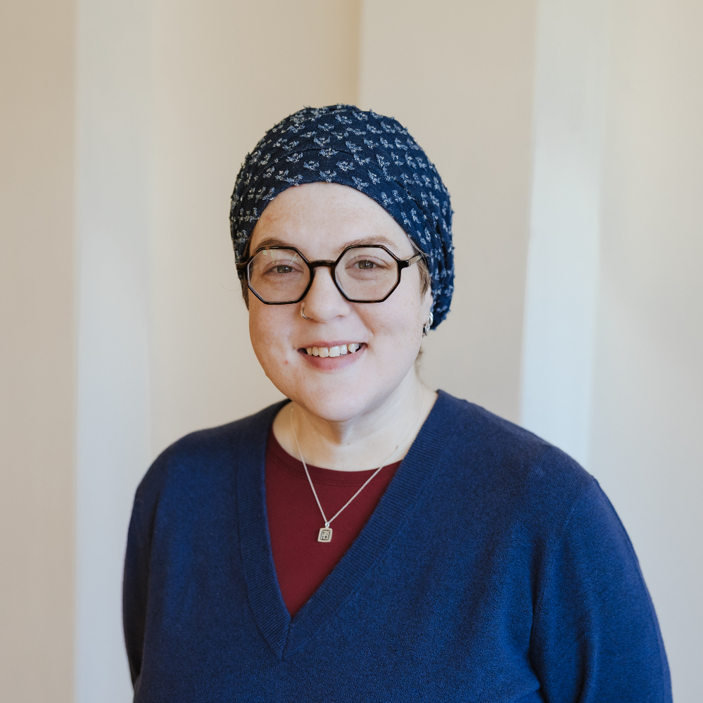 Person wearing glasses and smiling.