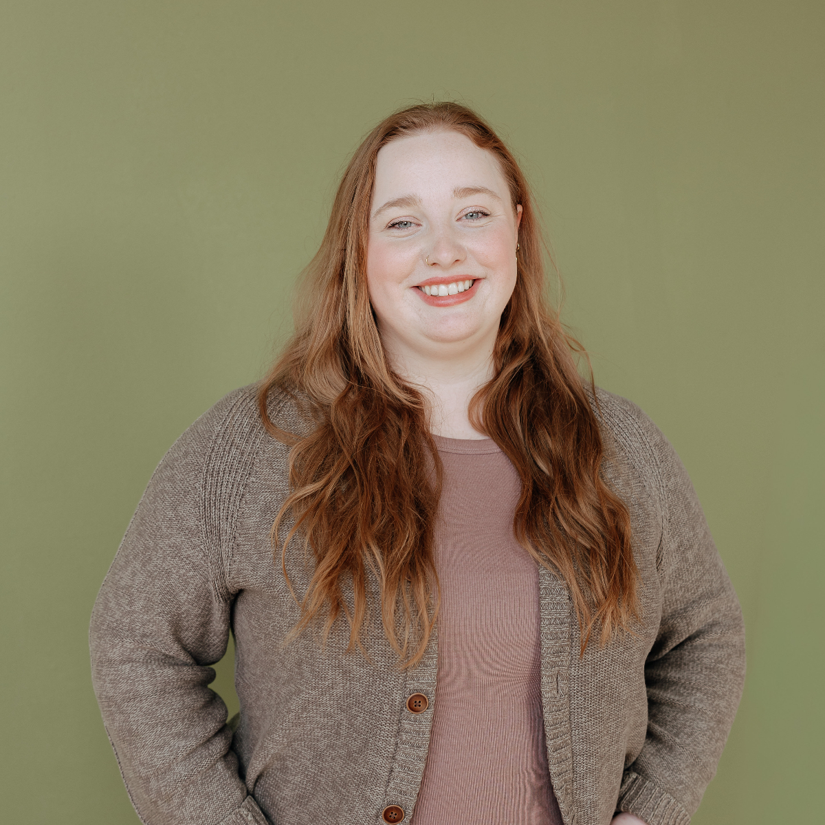 Person in a beige cardigan smiling at the camera.