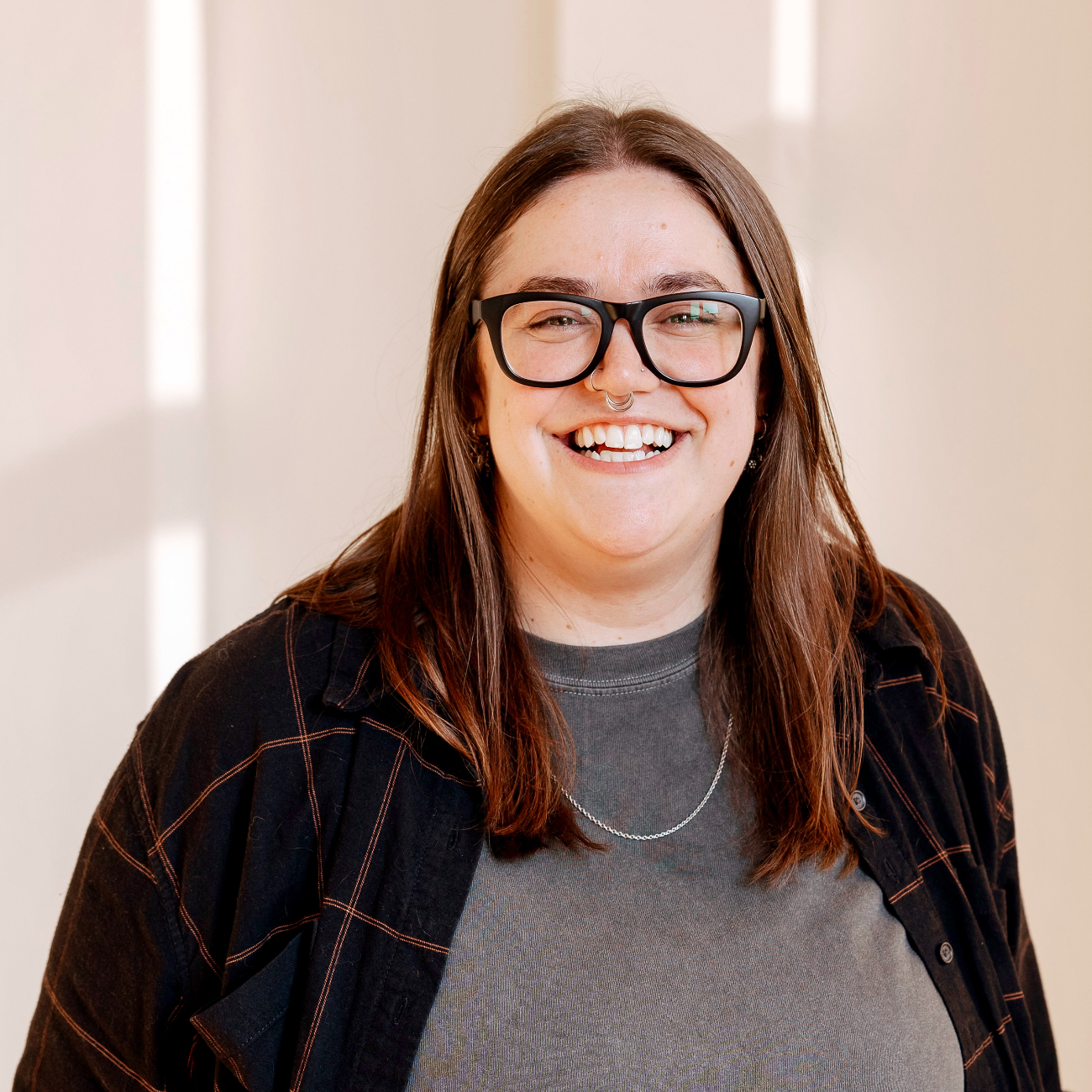 Person wearing glasses smiling at the camera.