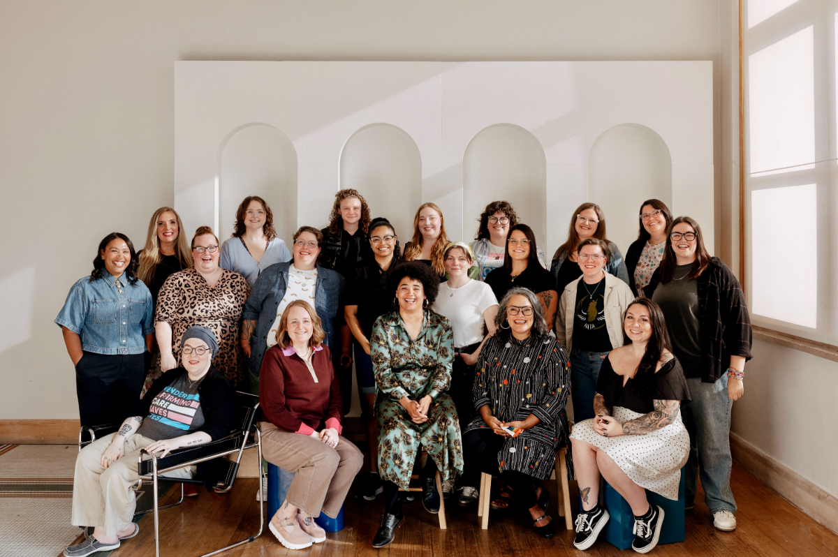 A group of people standing and sitting, smiling at the camera.
